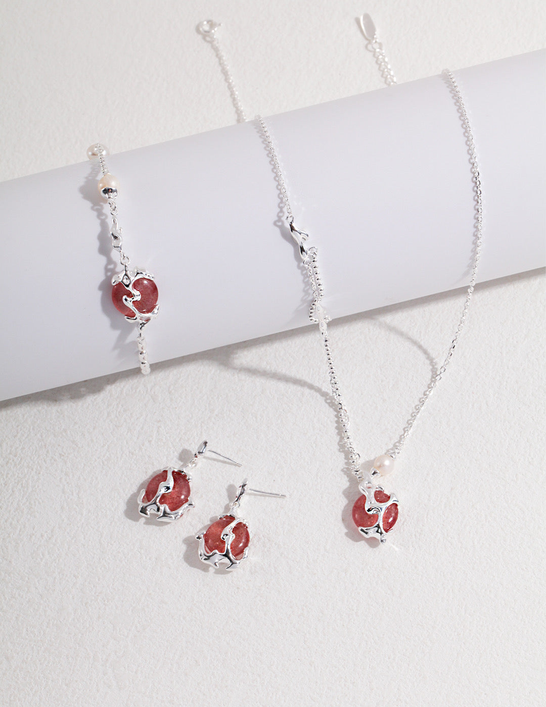 A set of strawberry quartz jewelry on white table