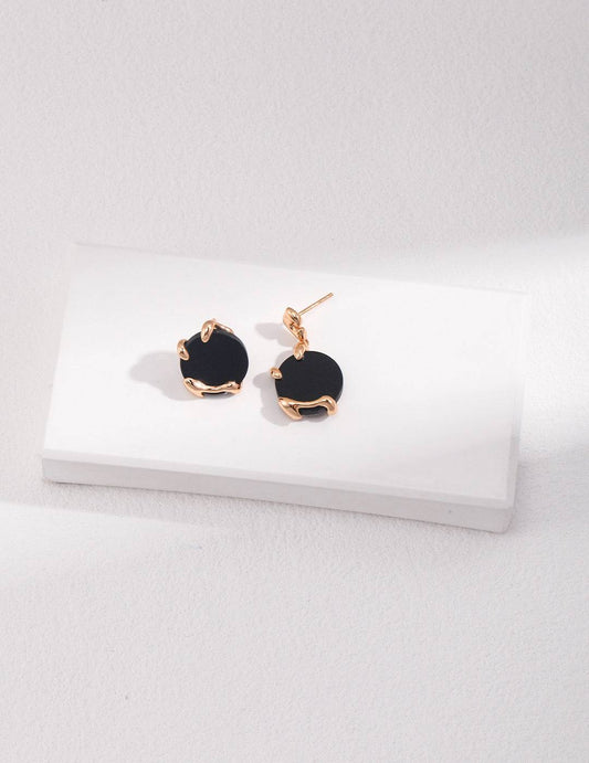 a pair of black agate stone and gold earrings on a white surface