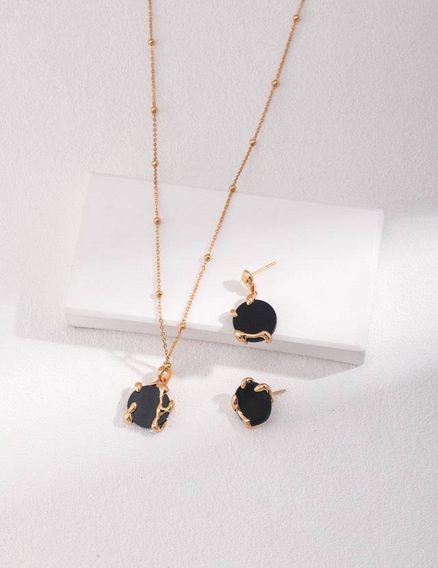 a necklace and earring set with a black agate stone