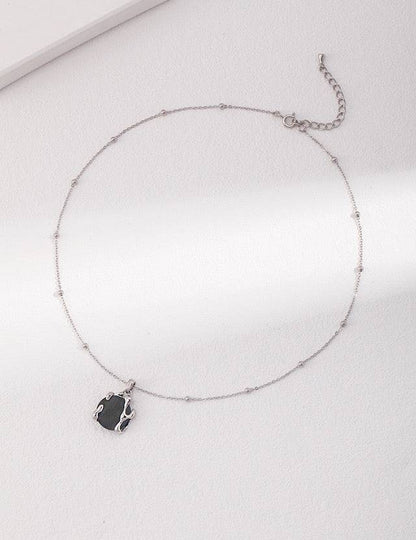 a necklace with a black agate stone on a silver chain