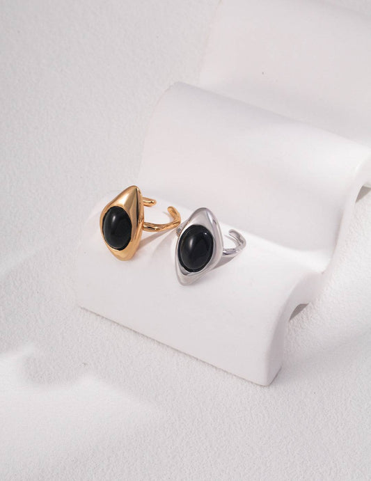 a pair of black agate rings sitting on top of a white surface