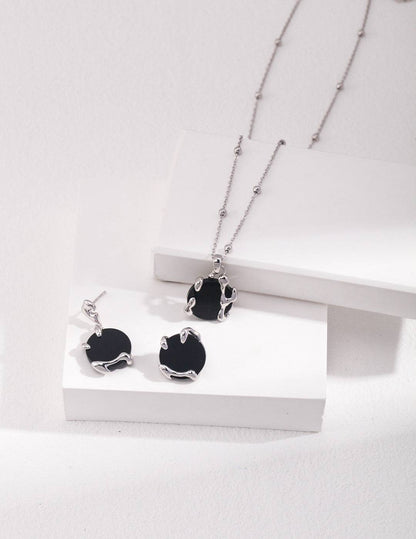 a pair of black and white necklaces on a white surface