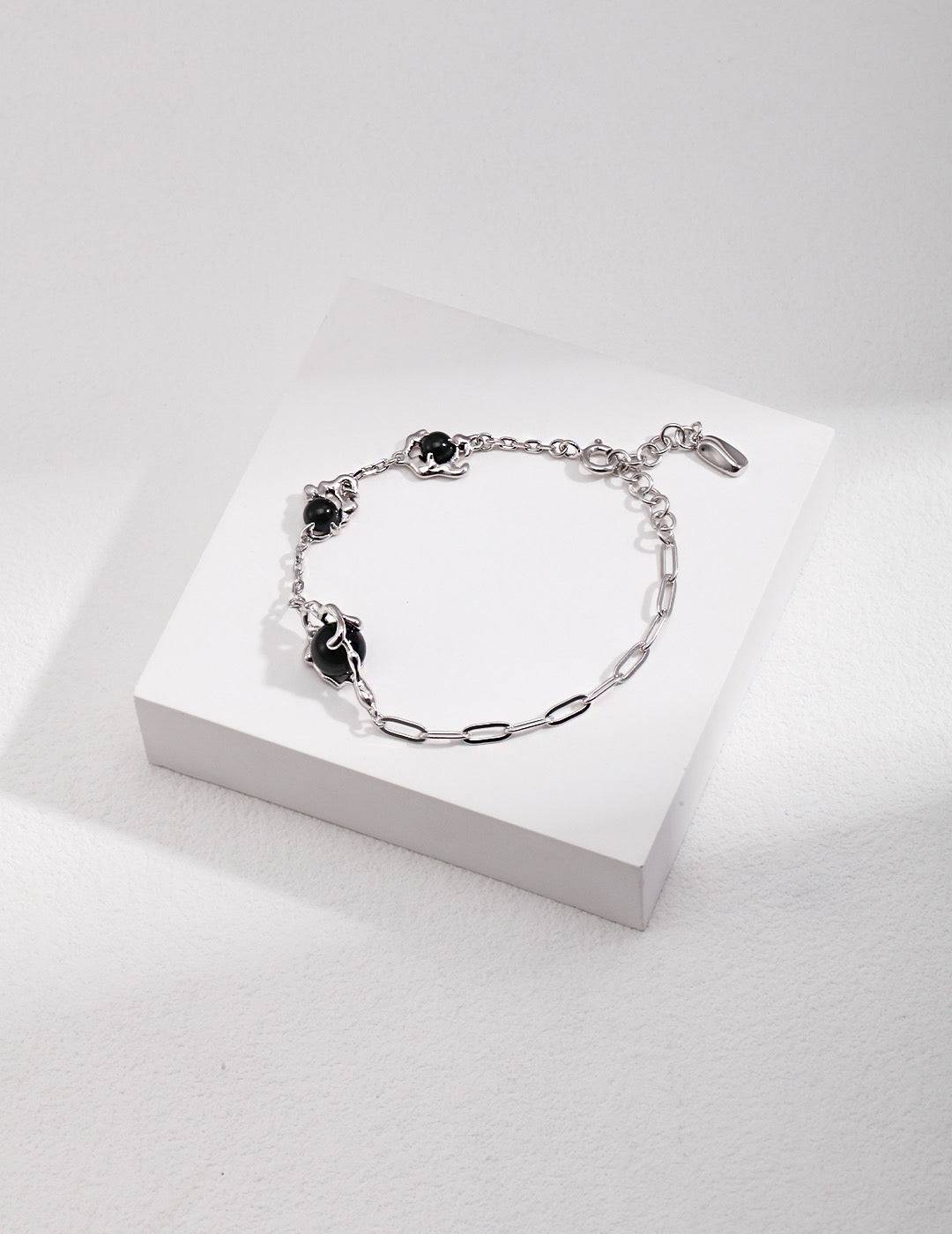 a silver chain bracelet with black agate stones