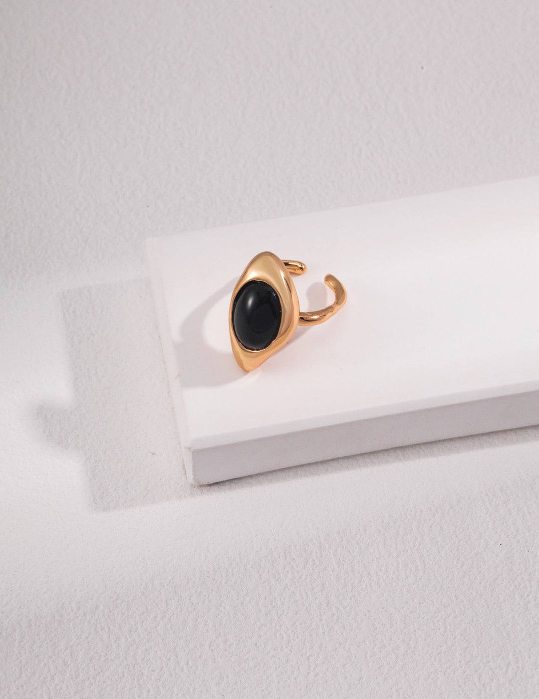 a gold ring with a black agate stone on it