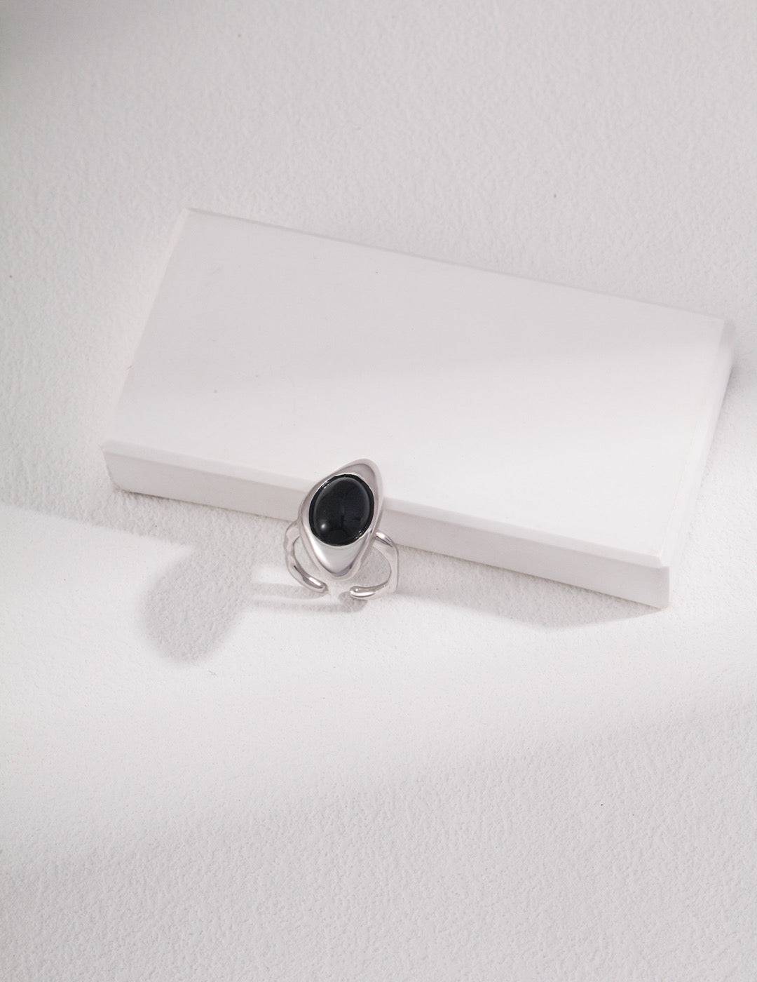 a silver ring with a black agate stone on it