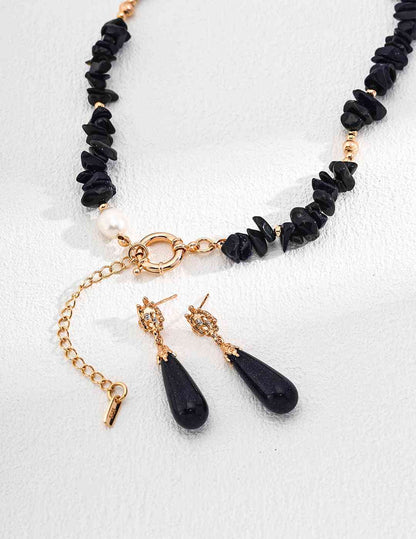 a blue sandstone beaded necklace and earrings with gold accents