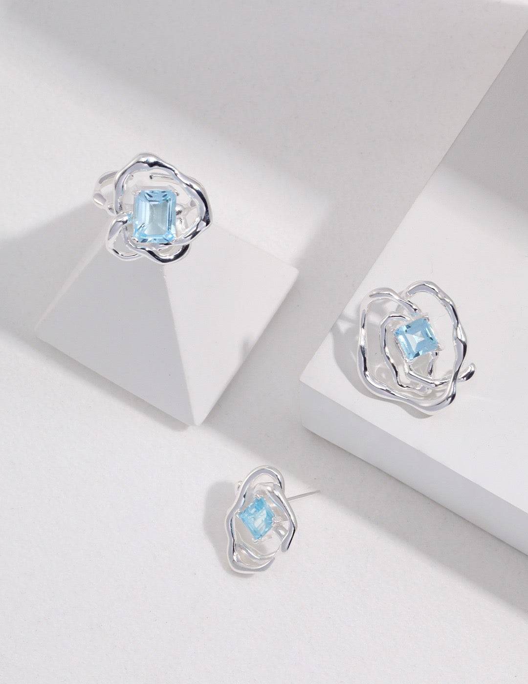 a pair of blue topaz earrings sitting on top of a white surface