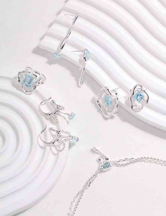 a set of blue topaz jewelry on a white surface