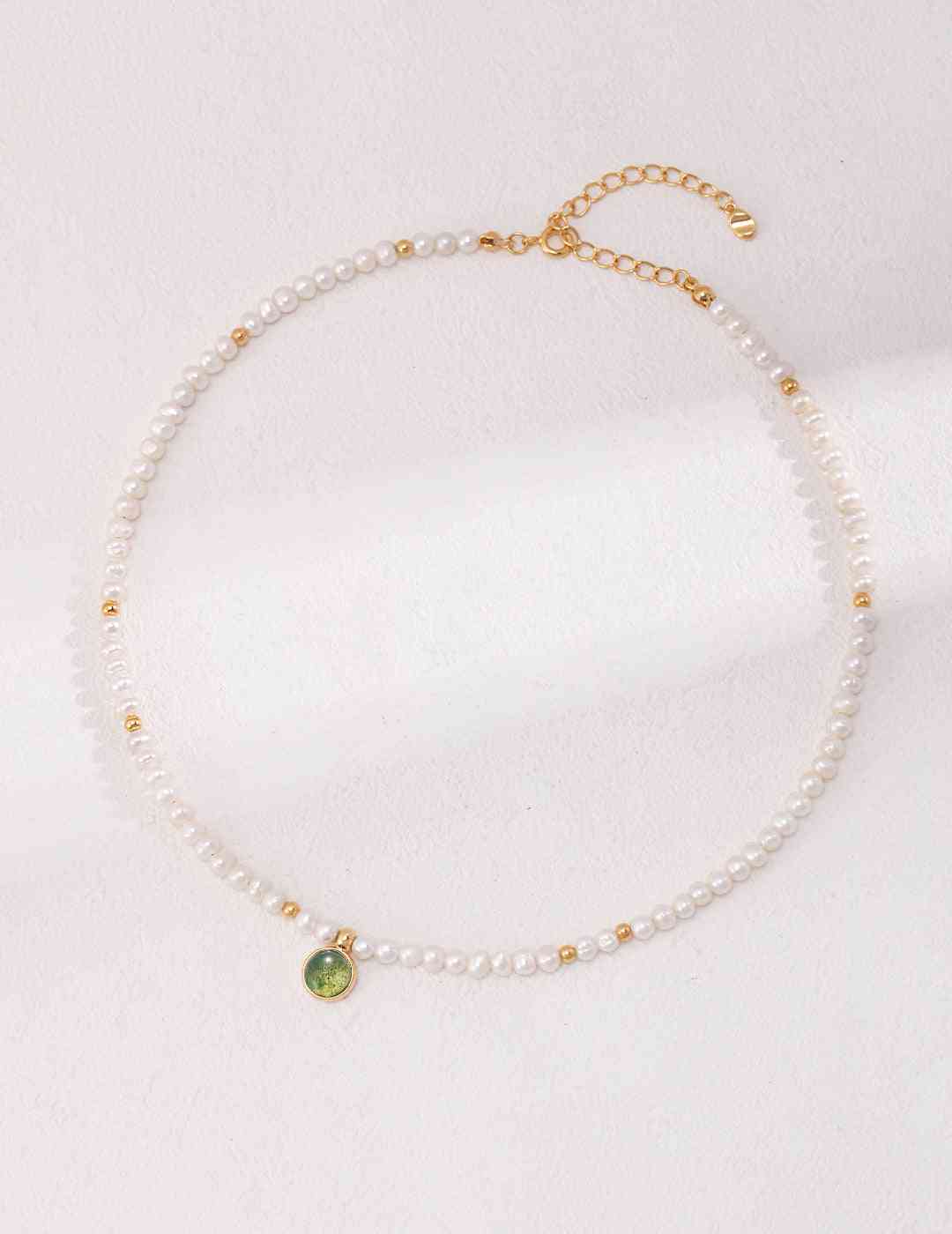 a necklace with pearls and a green aquatic agate stone