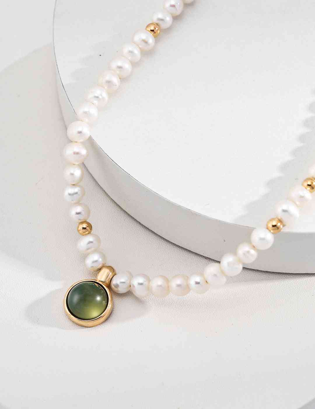 a white pearl necklace with a gold clasp