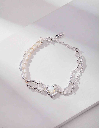 a silver bracelet with pearls and a opal stone