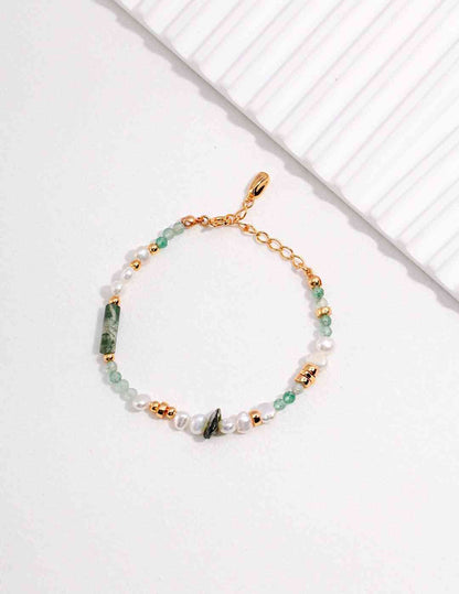 a gold chain bracelet with green and white beads