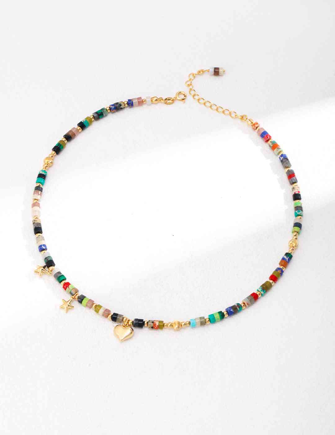 a multicolored beaded necklace on a white surface