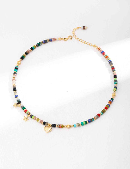a multicolored beaded necklace on a white surface