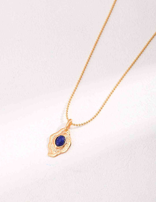a gold necklace with a blue lapis lazuli stone on it
