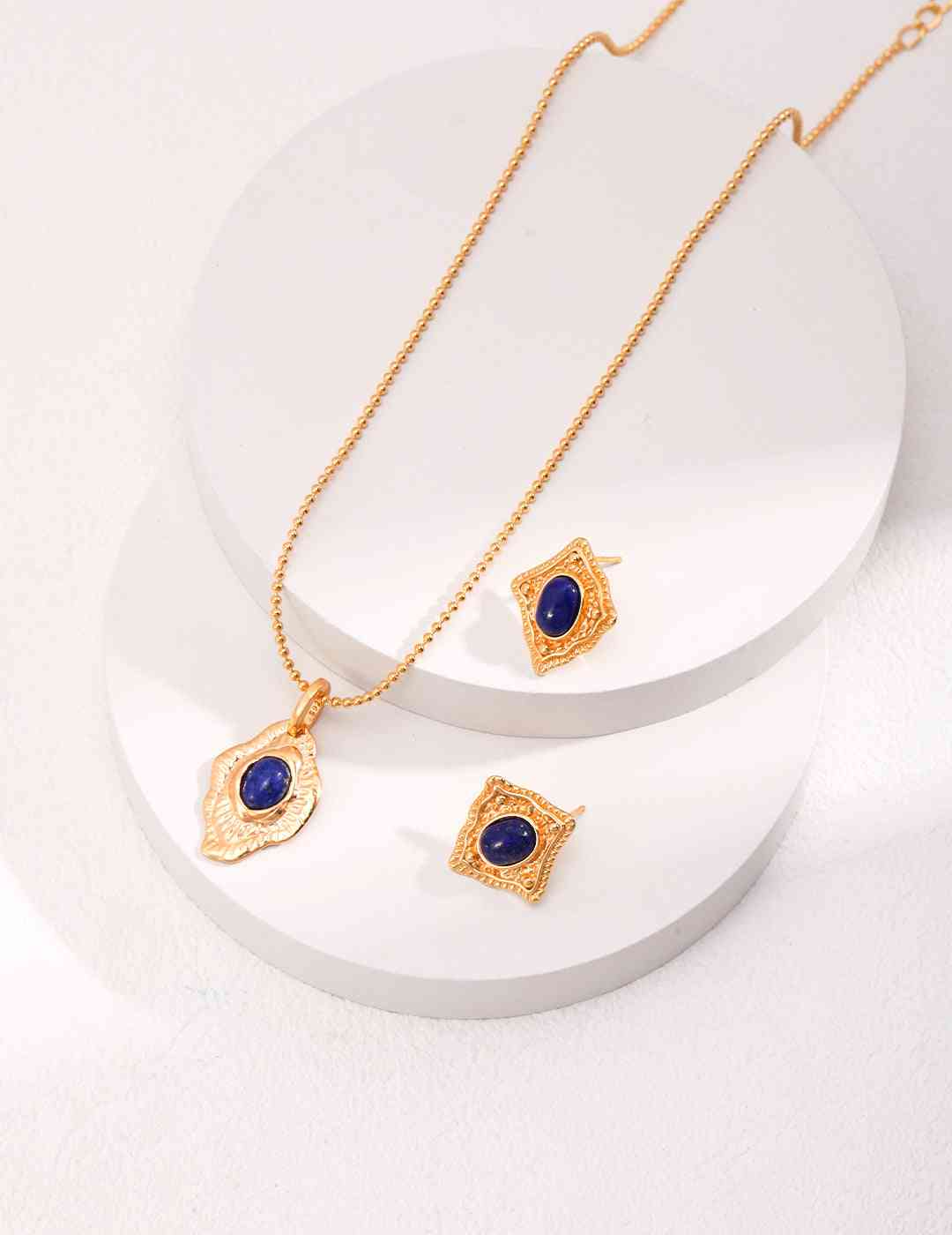 a necklace and earring set with a blue stone