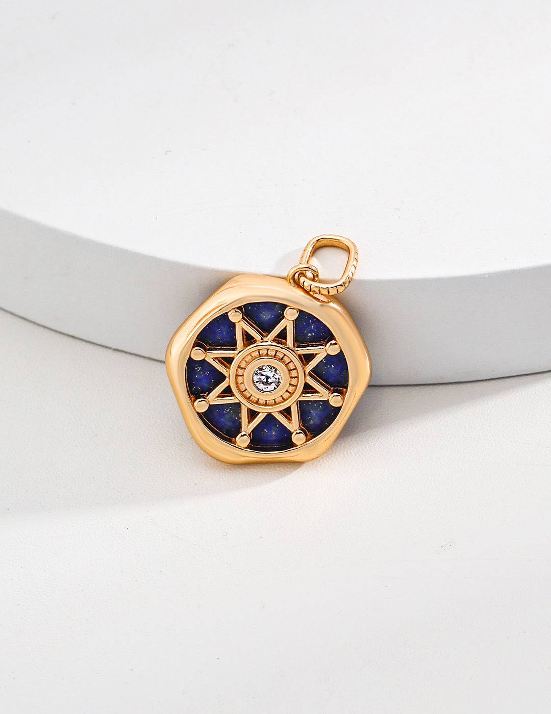 a gold plated pendant with a blue lapis lazuli stone in the center