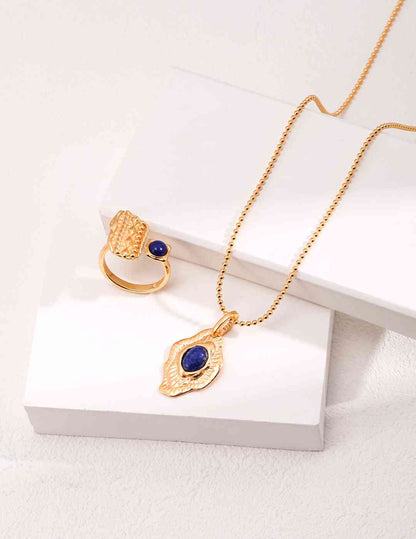 a gold necklace with a blue stone in the middle