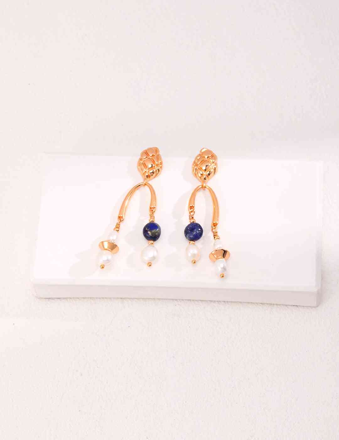 a pair of gold - plated earrings with blue stones and pearls