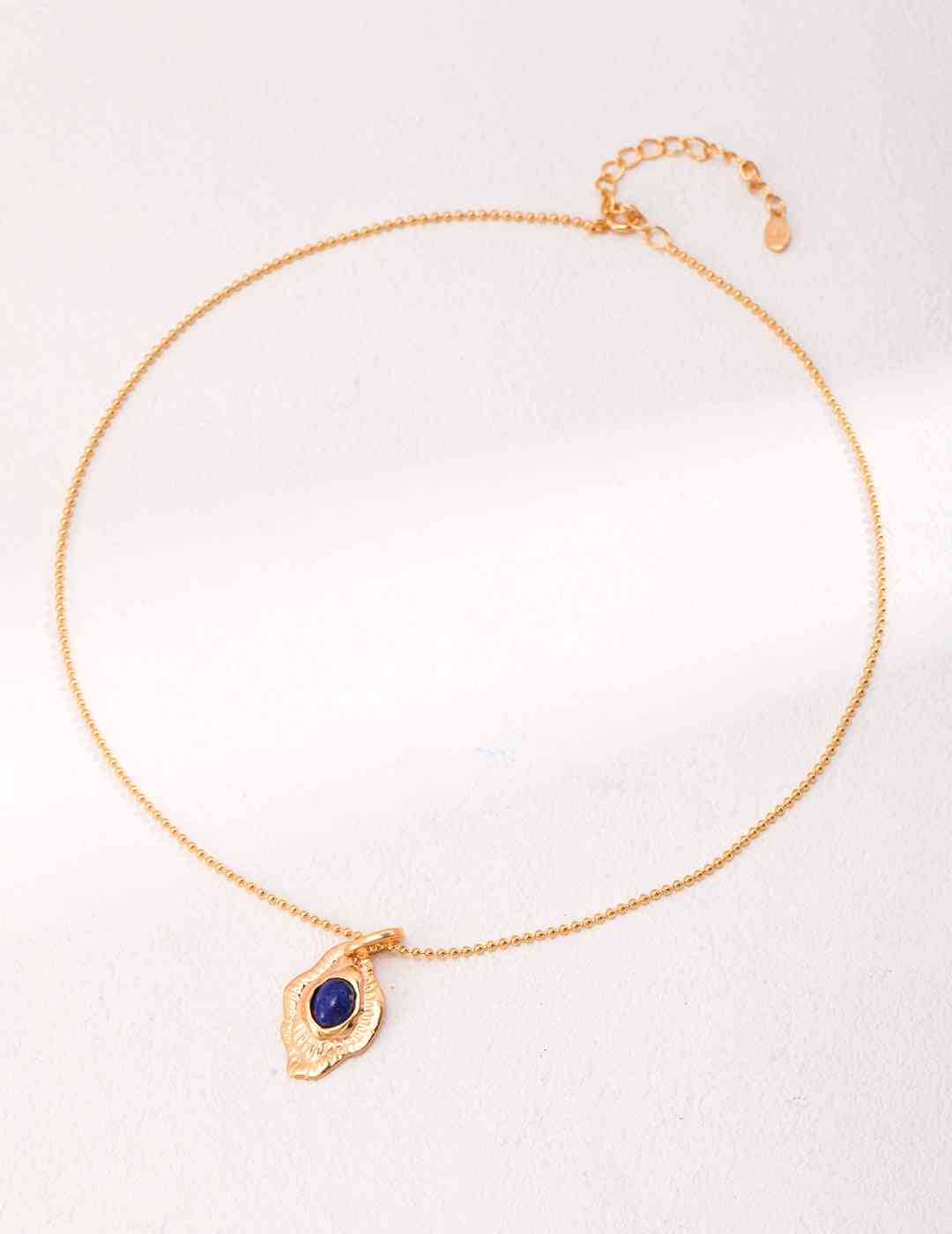 a gold bracelet with a blue lapis lazuli stone on it