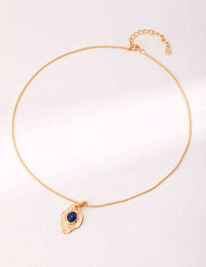 a gold bracelet with a blue lapis lazuli stone on it