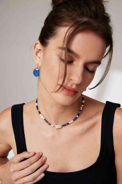 a woman wearing a necklace with a cross on it