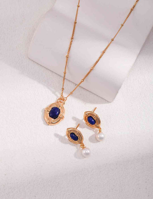 a necklace and earring set with a blue stone