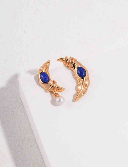 a pair of lapis lazuli earrings with pearl sitting on top of a white surface