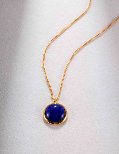 a gold necklace with a blue stone on it