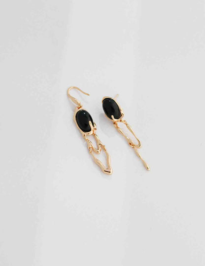 a pair of black agate and gold earrings on a white background