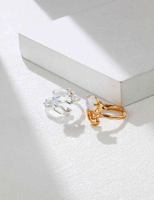a pair of opal stone rings sitting on top of a white box 