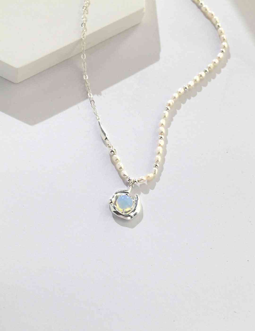 a silver necklace with a blue opal stone on it