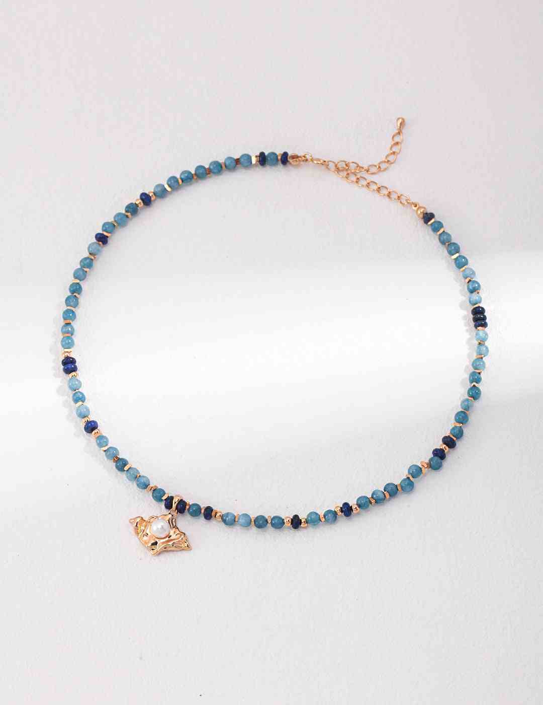 a blue amazonite beaded necklace with a gold charm