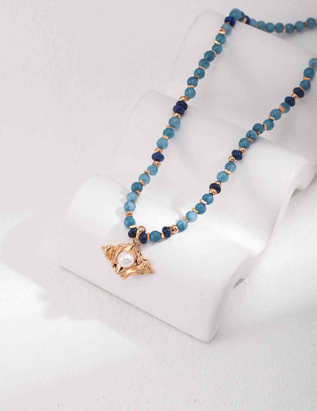 a blue amazonite beaded necklace with a gold star charm