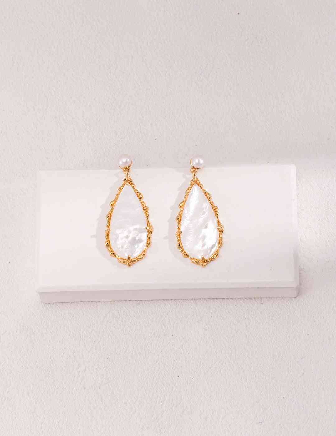 a pair of earrings on a white surface