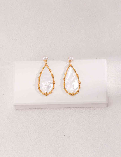 a pair of earrings on a white surface