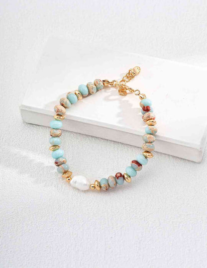 a bracelet with beads and a gold clasp