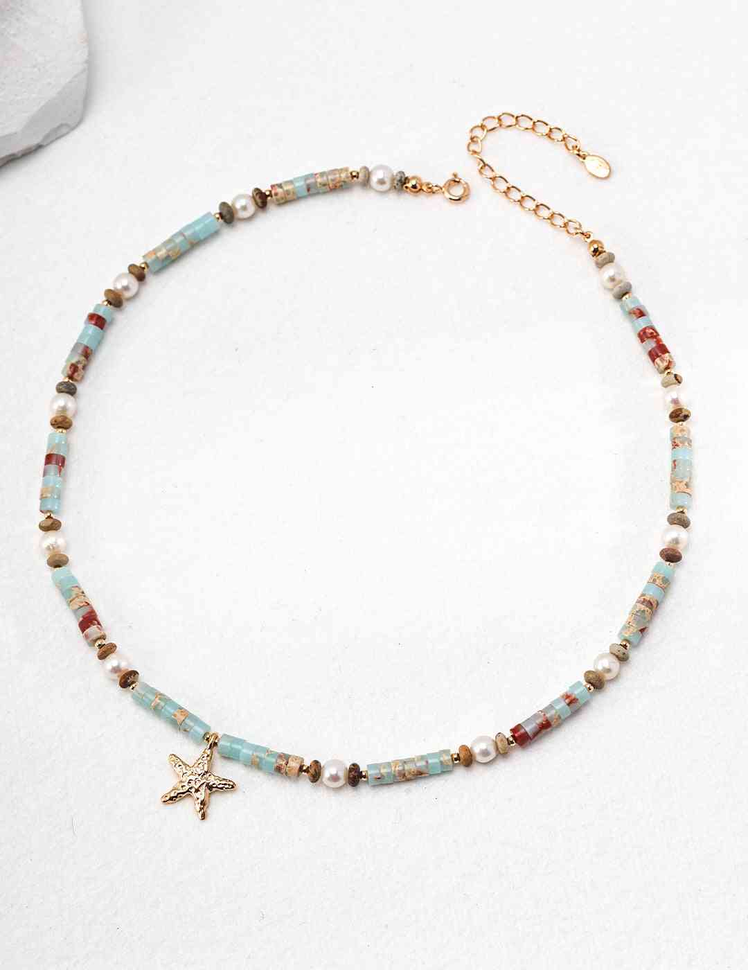 a beaded necklace with a starfish charm