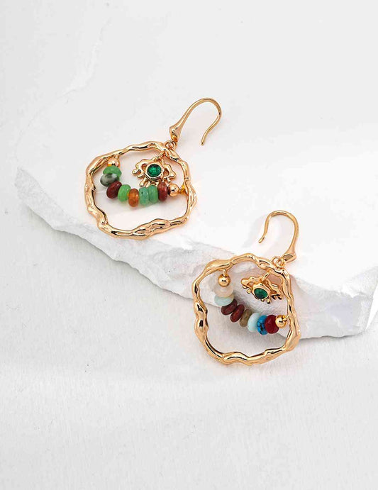 a pair of crystal stones earrings sitting on top of a white surface