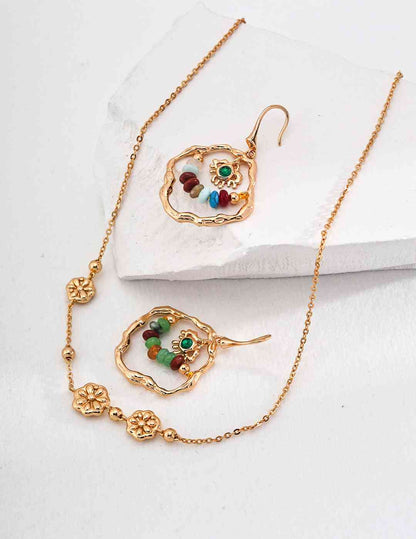 a pair of earrings and a necklace on a white surface