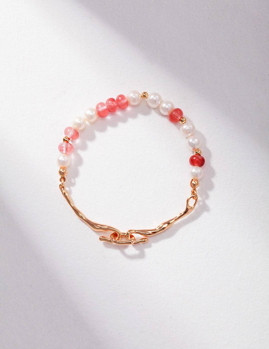 a gold bracelet with strawberry quartz and pearl beads