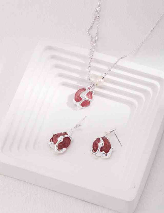 a necklace and earring set on a white tray