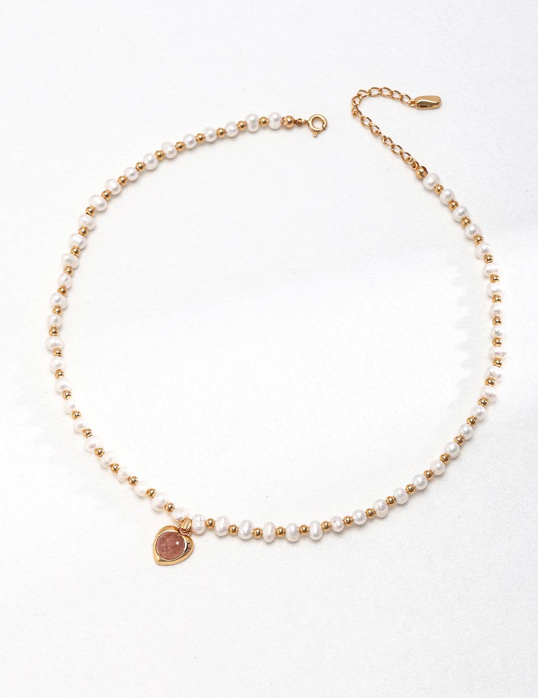 a pearl bracelet with a gold heart charm