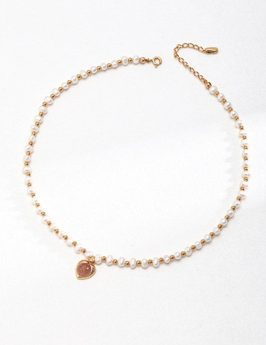 a pearl bracelet with a gold heart charm