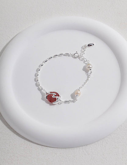 a white plate with strawberry quartz and silver bracelet on it