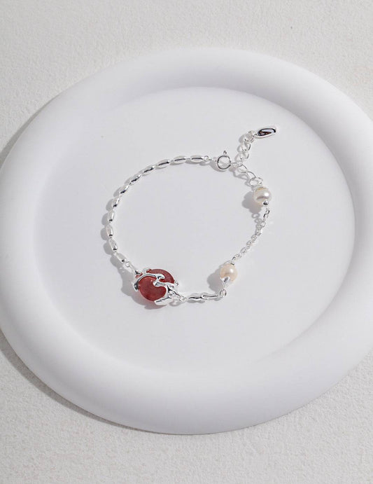 a white plate with strawberry quartz and silver bracelet on it