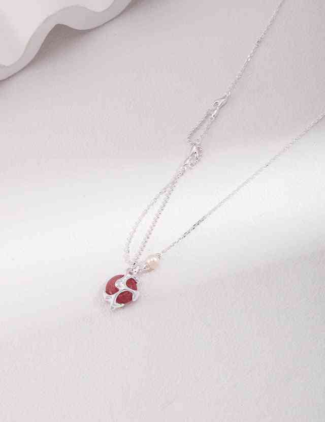 a silver necklace with strawberry quartz stone and pearl on it