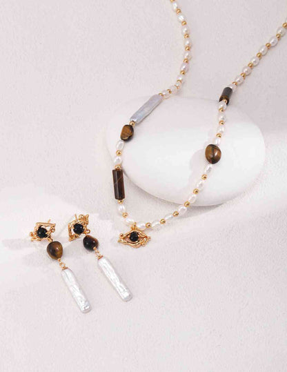 a necklace and earring set on a white surface