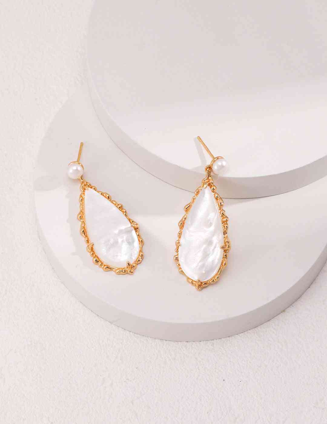 a pair of earrings on a white surface