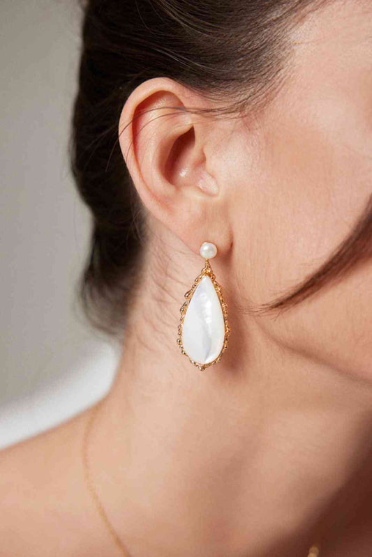 a close up of a person wearing a pair of earrings